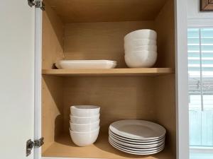 a cupboard with plates and bowls in it at The Blue Luzon Cozy Bungalow 5 min Downtown in Houston +55 photos