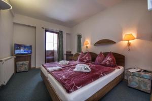 a bedroom with a large bed with purple sheets at Penzión Pleso in Štrbské Pleso