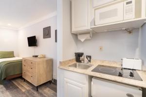 a small kitchen with a sink and a bed at Mountainside Inn 103 by Alpine Lodging Telluride in Telluride