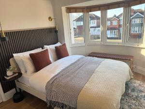 a bedroom with a large bed and two windows at Luxury House sleeps 8 - Ideal for Solihull NEC - Work and Family Groups in Birmingham