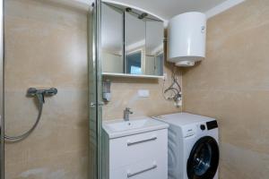 ein Badezimmer mit Waschmaschine und Waschbecken in der Unterkunft COY Apartments Kaltenleutgeben - Nature Meets Style in Kaltenleutgeben + 37 Fotos