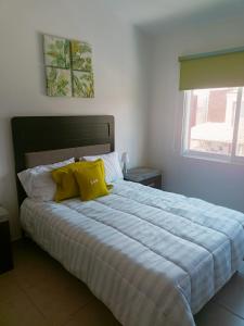 a bedroom with a large bed with yellow pillows at Riberas del Chante, casa de descanso in Jocotepec