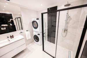 a bathroom with a shower and a washing machine at Luksusowy Apartament Przy Parku in Tarnowskie Góry