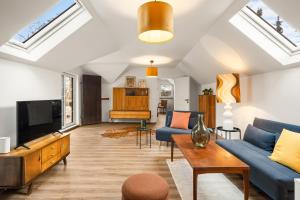 a living room with a blue couch and a tv at Press4Living Cottage near Vienna in Ebenthal
