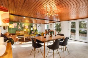 a living room with a wooden ceiling and a table and chairs at Press4Living Cottage near Vienna in Ebenthal