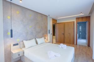 a bedroom with a large white bed and a wall at Résidence Tour 33 - CFC district in Casablanca