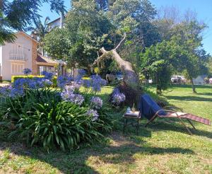 a garden with purple flowers and a bench in a yard at Chácara Rosa Cortiana in São Gabriel