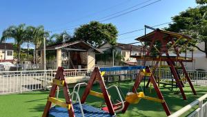 a playground with a slide and a swing set at Descanso e Tranquilidade em Guaratiba in Rio de Janeiro