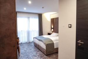 a hotel room with a bed and a window at JG Hotel & Restaurant Antoniergasse in Memmingen +16 photos