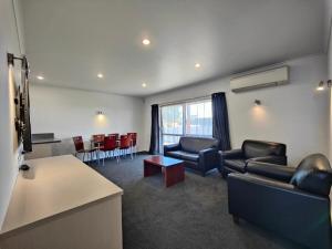 a waiting room with couches and chairs and a table at Camden Court Apartment in Invercargill