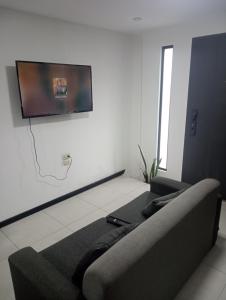 a living room with a couch and a flat screen tv at Mini suit in Loja
