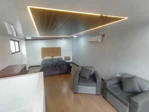 a bedroom with a bed and a couch at Mini suit in Loja