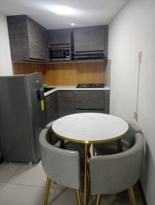 a kitchen with a table and chairs and a refrigerator at Mini suit in Loja