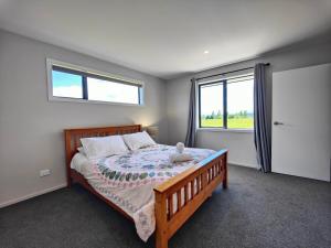 Un dormitorio con una cama con un osito de peluche encima. en Mountain View Getaway, en Te Anau 23 fotos más