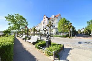 eine Reihe von Parkbänken vor einem Gebäude in der Unterkunft Ferienwohnung Binzer Strandgut im Haus Jahreszeiten Binz in Binz