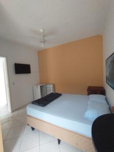 una camera da letto con un letto in una stanza di kitnet & Suítes Aloha Beach Bertioga a Bertioga