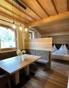a dining room with a wooden table and a bed at Gästehaus Emberger in Wagrain