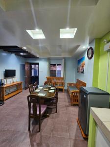 a dining room with a table and chairs and a tv at MF Apartments in Baguio