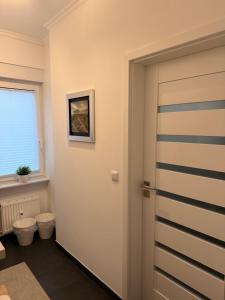 a bathroom with a door and a toilet and a window at Modernes 1 Zimmerapartment nahe Frankfurt am Main in Heusenstamm