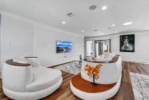 a living room with two white chairs and a table at Luxury 4 bedroom villa in Huntington Beach