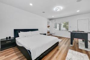 a white bedroom with a bed and a desk at Luxury 4 bedroom villa in Huntington Beach