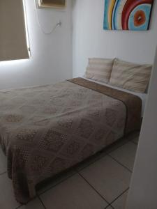 a bed in a white room with a blanket on it at Barra Rio Centro in Rio de Janeiro +29 photos