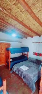 Un dormitorio con una cama y un techo de madera. en Mamacoca, en Purmamarca