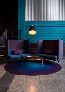 una habitación con 2 sofás, una mesa y una lámpara en Ovolo Woolloomooloo en Sídney