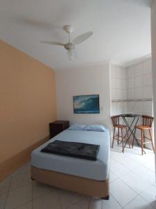 una camera da letto con un letto e un tavolo con sedie di kitnet & Suítes Aloha Beach Bertioga a Bertioga
