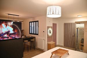 a living room with a table and a kitchen with a tv at Suite and spa jacuzzi sauna proche Paris in Presles