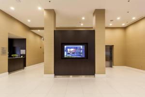a lobby with a tv on a wall at Courtyard by Marriott Montreal West Island/Baie D’Urfe in Baie-dʼUrfé