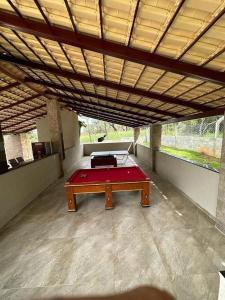Una habitación grande con una mesa de billar roja. en Area de Lazer fazenda Papuã- Lugar de PAZ, en Caldas Novas