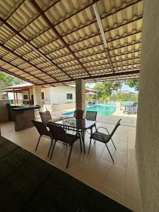 Un patio con mesa y sillas y una piscina. en Area de Lazer fazenda Papuã- Lugar de PAZ, en Caldas Novas