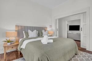 a bedroom with a large bed with a white object on it at Settlers Cottage and Settle Inn in Broadwater