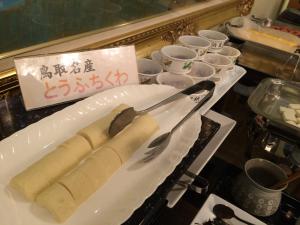 a white plate with a knife and fork on a table at Tottori City Hotel in Tottori