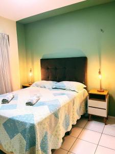 a bedroom with a large bed and a green wall at Ap com ar condicionado, cozinha equipada, piscina in Imperatriz