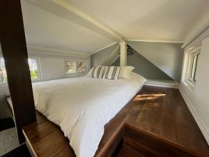 a large white bed in a room with two windows at Tiny House Mercedes in Mercedes