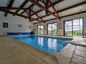 duży basen w pokoju z drewnianym sufitem w obiekcie Séjournez en Ferme avec Piscine, Tennis, Chevaux et Parking Sécurisé - FR-1-582-518 w mieście Saint-Romain-Lachalm