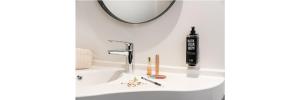 lavabo con espejo y secador de pelo negro en ibis Acheres St Germain en Laye, en Achères