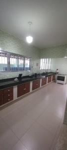 a large kitchen with brown cabinets and a white tile floor at Casa no Centro in Rio das Ostras