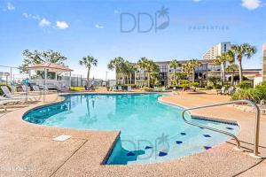una piscina en un complejo con palmeras en Ocean Club Villa B-220, en Biloxi