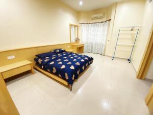 a bedroom with a bed and a desk in it at KUDIMAN Homestay 2 in Kuala Terengganu