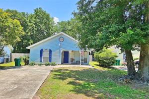 a blue house with a flag in front of it at 24th Street House in Gulfport