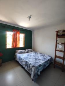 a bedroom with a bed and a window at Casa na Beira da Praia de Capão da Canoa in Capão da Canoa