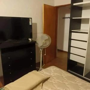 a bedroom with a bed and a dresser and a fan at Chalet los aromos in Villa Los Aromos