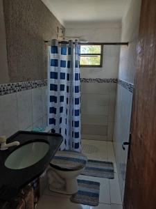 a bathroom with a sink and a toilet and a shower at Casa na Beira da Praia de Capão da Canoa in Capão da Canoa +9 photos