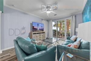 un soggiorno con 2 divani in pelle blu e una TV di Legacy Tower Two 107 Deluxe a Gulfport