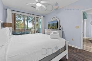 una camera con un grande letto bianco e una TV di Legacy Tower Two 107 Deluxe a Gulfport