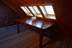 a vase sitting on a wooden table with a window at Barn Bed and Breakfast in Waitati