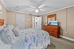 Un dormitorio con una cama y una cómoda con televisión. en Ocean Club Villa B-317, en Biloxi